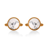 Pair of cufflinks with gold frames and white marbled centers on a white background