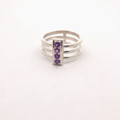 Silver ring with purple gemstones on a white background