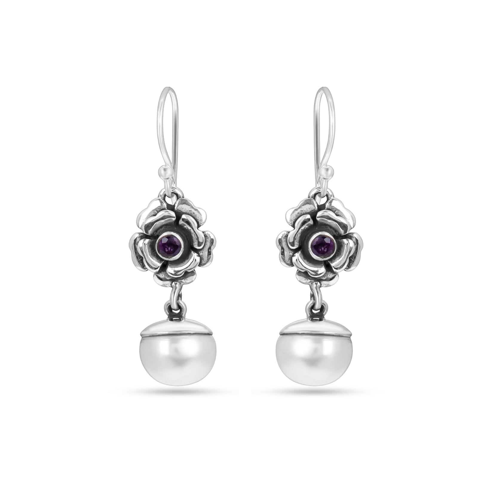 Silver earrings with floral designs and purple gemstones on a white background