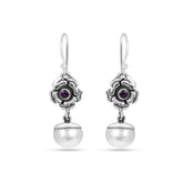 Silver earrings with floral designs and purple gemstones on a white background