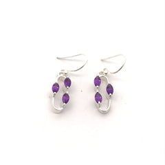 Silver earrings with purple beads on a white background