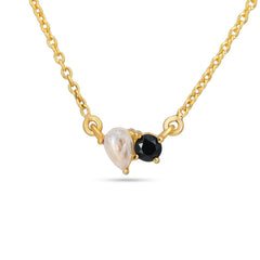 Gold necklace with a black gemstone and a pearl on a white background