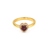 Gold ring with a heart-shaped gemstone on a white background