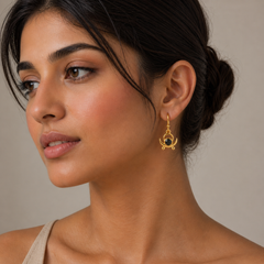 Woman wearing gold earrings with a neutral background
