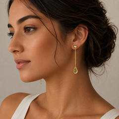 Close-up of a woman wearing gold earrings with a neutral background