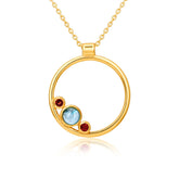 Gold necklace with a circular pendant featuring three colored stones on a white background