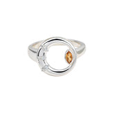 Silver ring with a central brown gemstone and smaller clear stones on a white background