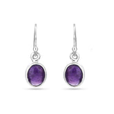 Silver earrings with purple gemstones on a white background