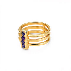 Gold ring with purple gemstones on a white background