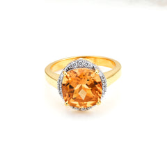 Gold ring with a large orange gemstone and smaller diamonds on a white background