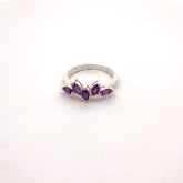 Silver ring with purple gemstones on a white background