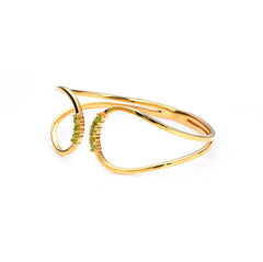 Gold bracelet with green gemstones on a white background