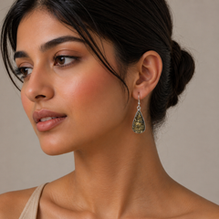 Woman wearing a teardrop-shaped earring with a beige background