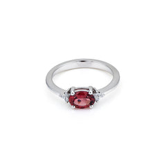 Silver ring with a red gemstone on a white background