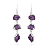 Pair of silver earrings with purple gemstones on a white background
