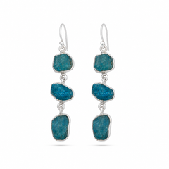 A pair of silver drop earrings featuring three raw, irregular blue- stones in each earring, suspended from silver fishhook wires, shown against a plain white background.