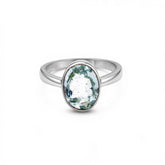 Silver ring with a green gemstone on a white background