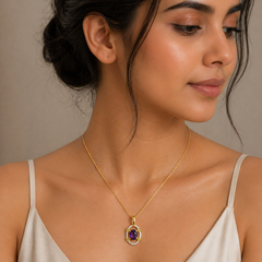 Woman wearing a gold necklace with a pendant against a neutral background