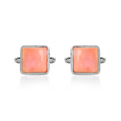 Pair of square pink cufflinks with silver borders on a white background