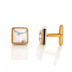 Gold cufflinks with marble and blue stone design on a white background