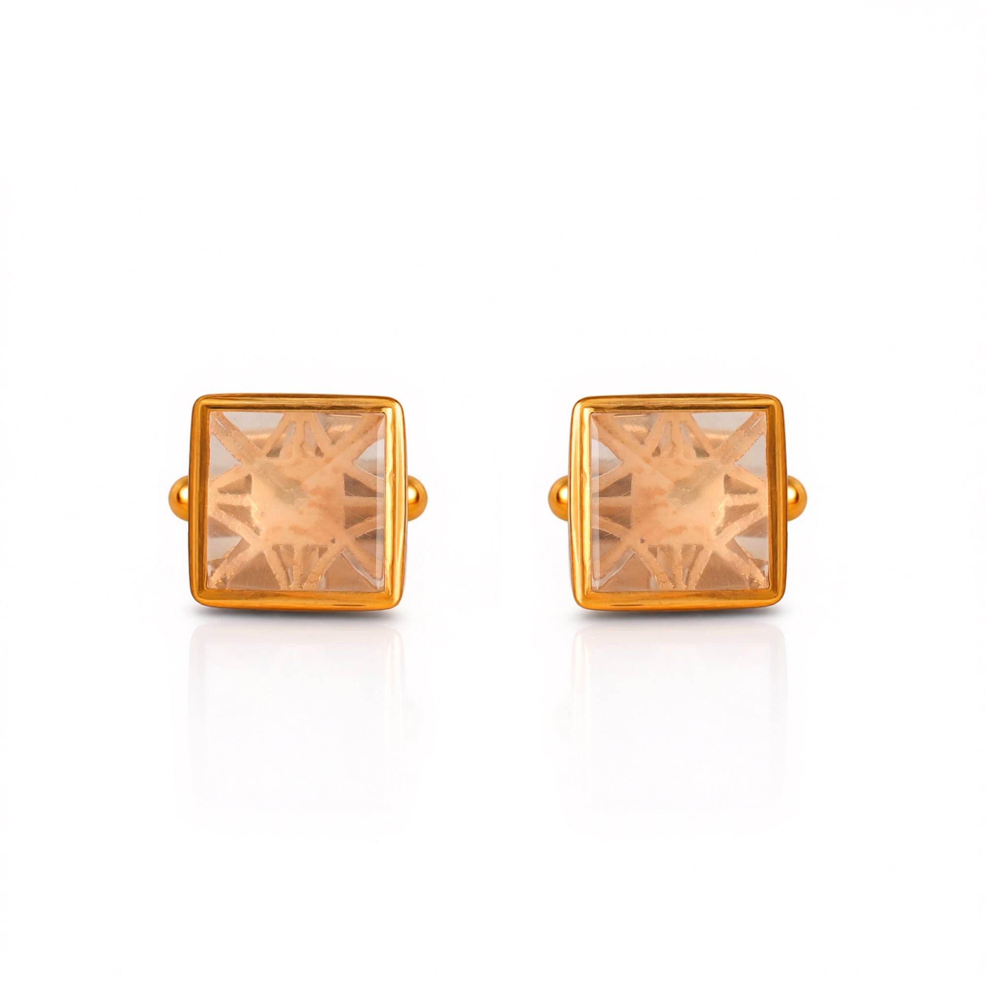Gold square-shaped earrings with clear gemstones on a white background