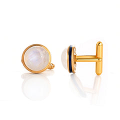 Gold cufflinks with gemstone and black enamel accents on a white background
