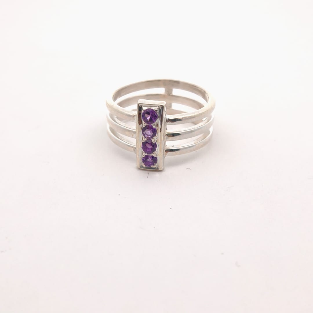 Silver ring with purple gemstones on a white background