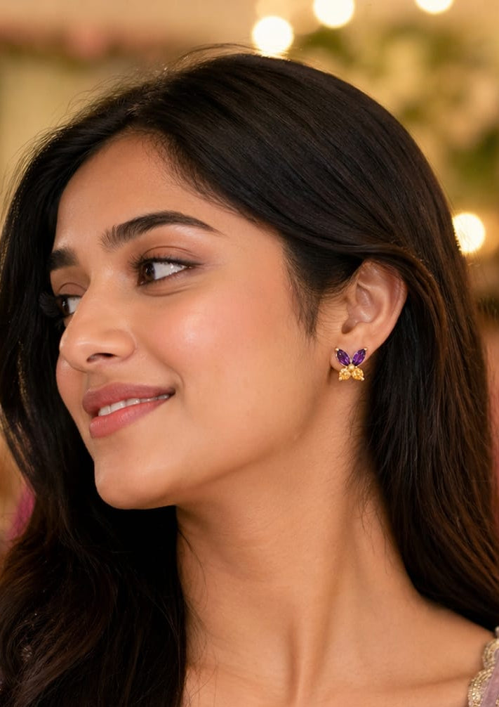 Woman wearing a purple embroidered outfit with gold jewelry in a festive setting