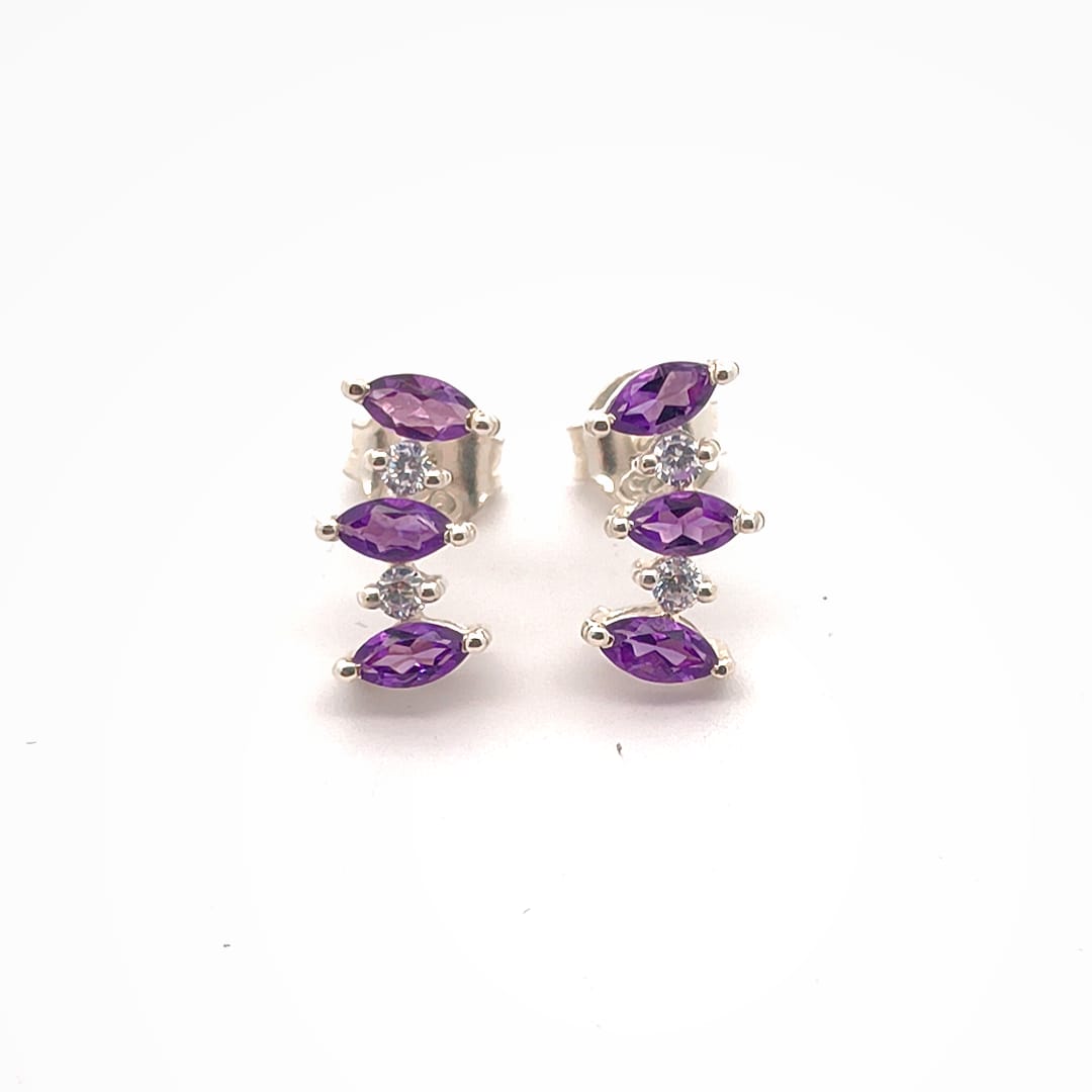 Pair of silver earrings with purple gemstones on a white background