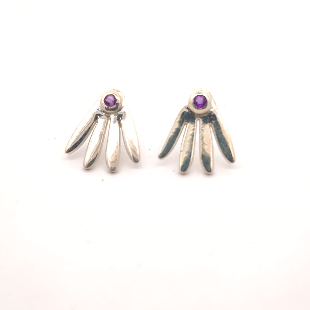 Pair of silver earrings with purple gemstones on a white background