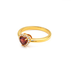 Gold ring with a heart-shaped gemstone on a white background
