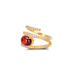 Gold ring with a red gemstone on a white background