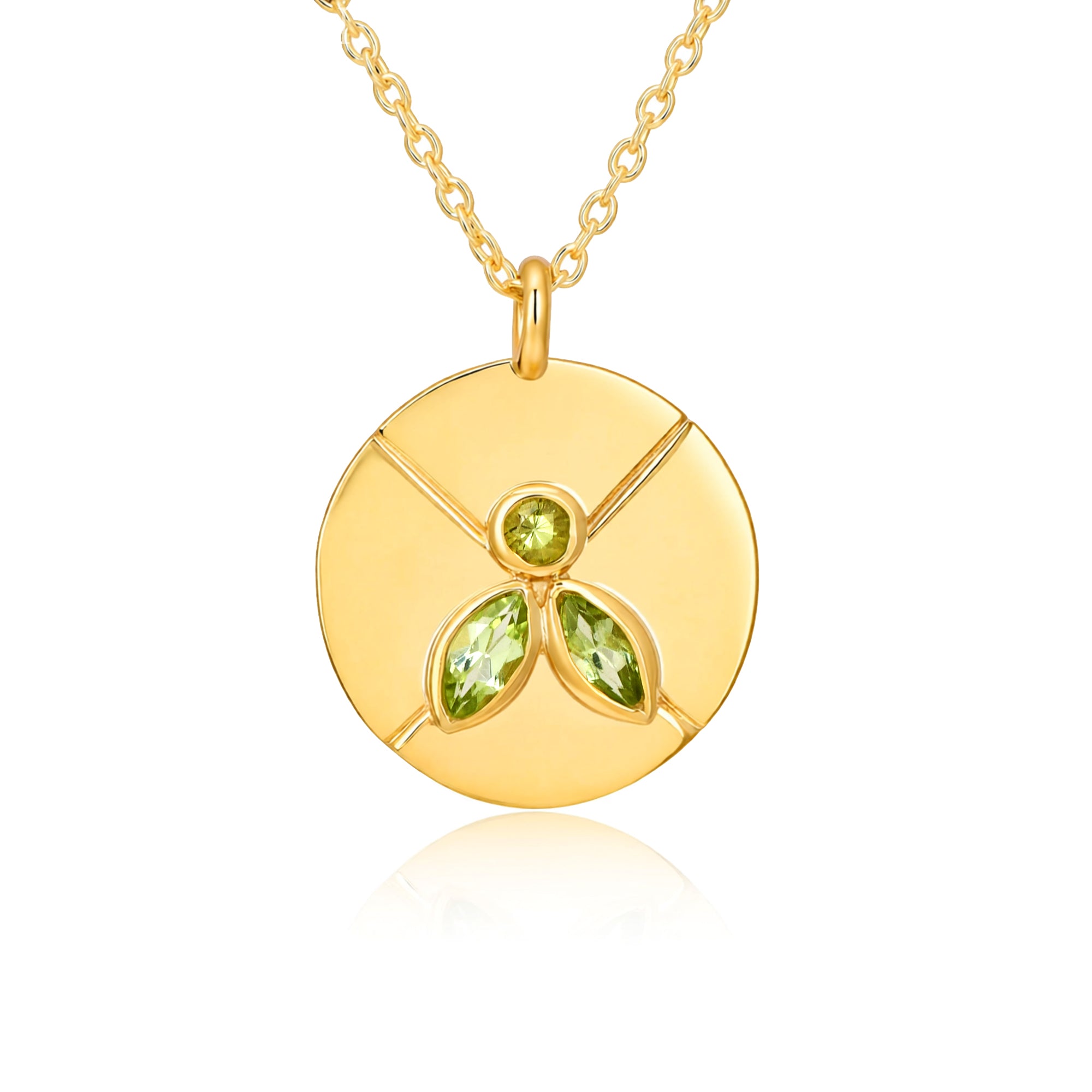 Gold necklace with a circular pendant featuring green gemstones on a white background