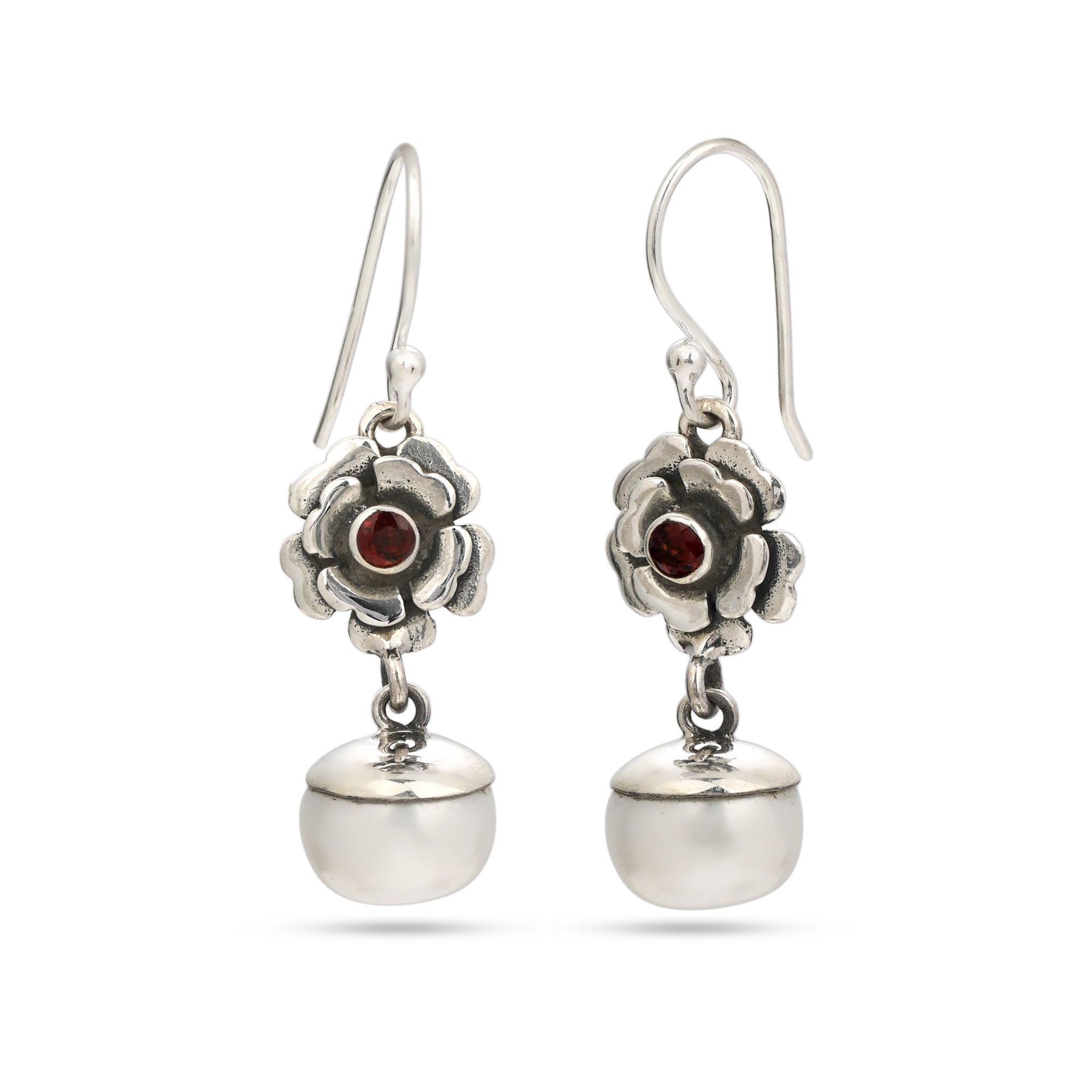 Silver earrings with floral designs and red gemstones on a white background