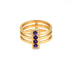 Gold ring with purple gemstones on a white background
