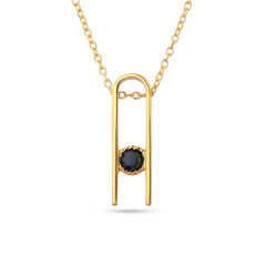 Gold necklace with a black gemstone pendant on a white background