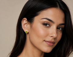 Woman wearing a green earring against a neutral background