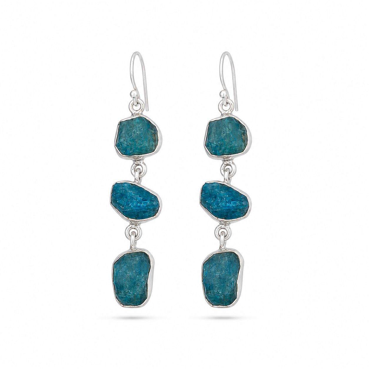 A pair of silver drop earrings featuring three raw, irregular blue- stones in each earring, suspended from silver fishhook wires, shown against a plain white background.