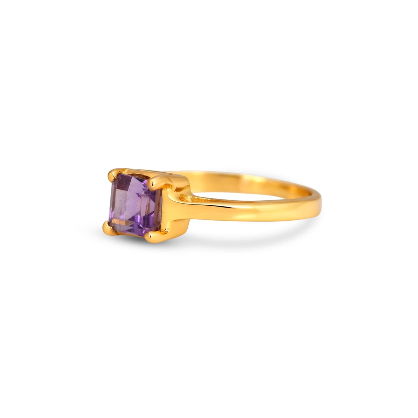 Gold ring with a purple gemstone on a white background